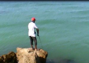 Pesca in Oman Sud da riva, foto di uno spot sulle coste nel Dhofar, intorno a Salalah nel Mar Arabico, parte dell' Oceano Indiano. Recupero dell' artificiale a spinning.